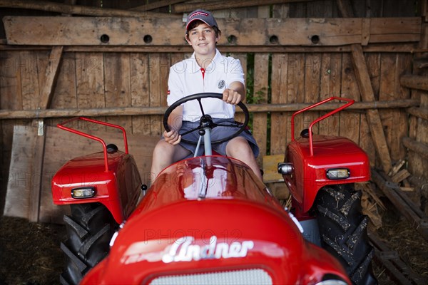 Boy sitting on a vintage tractor