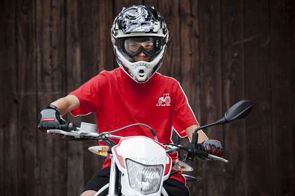 Boy wearing a helmet sitting on a motorcycle