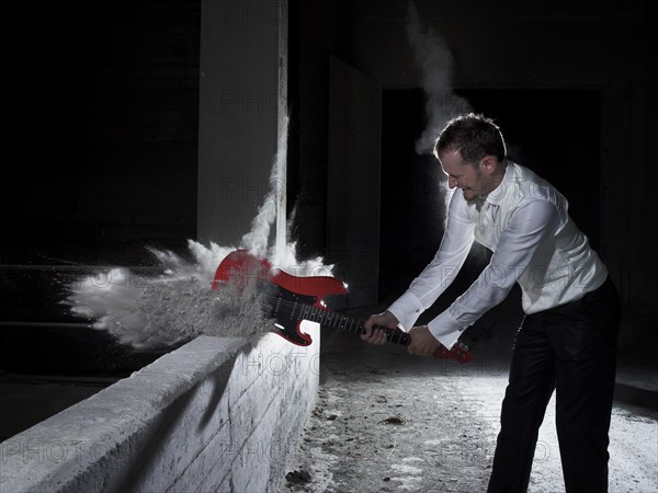 Man smashing an electric guitar