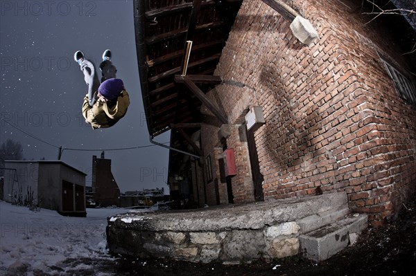 Freerunner doing a somersault at an old industrial site