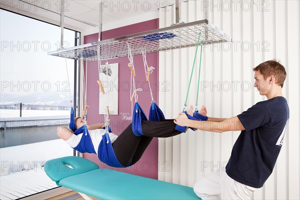 Patient and physiotherapist during sling table therapy