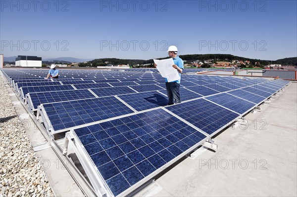 Two technicians inspecting a solar energy plant