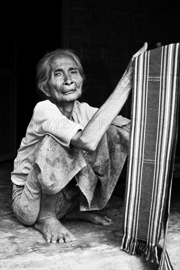 Elderly Indonesian woman selling fabrics