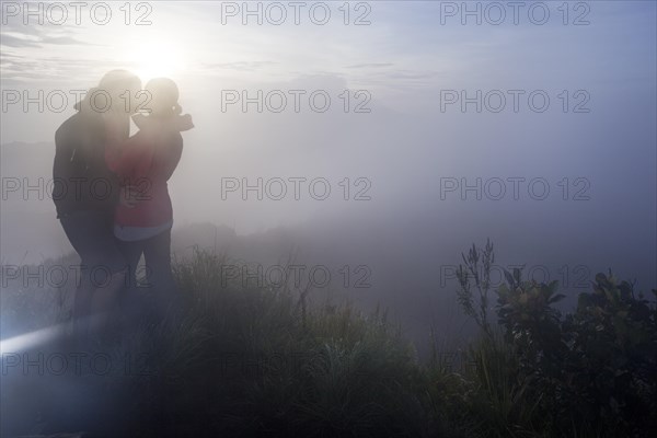 Couple kissing in the fog on the Gunung Agung volcano