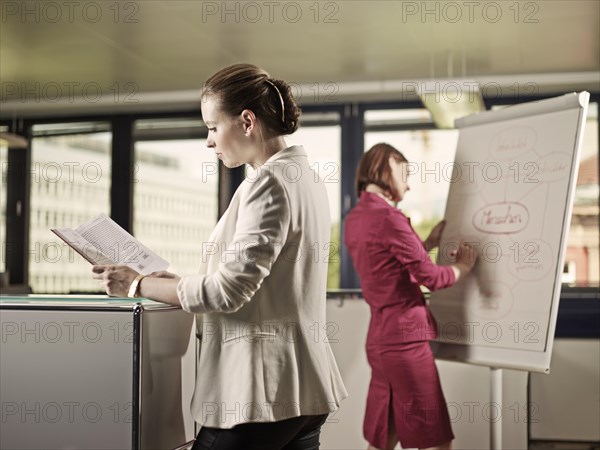 Woman reading a book in an office