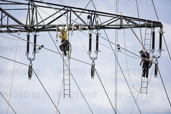 High-voltage service technicians installing a new high voltage power line