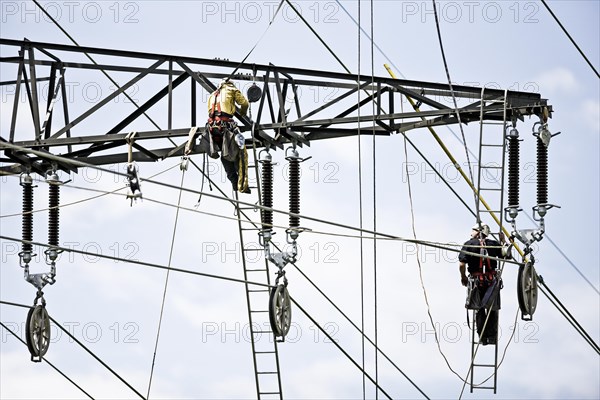 High-voltage service technicians installing a new high voltage power line