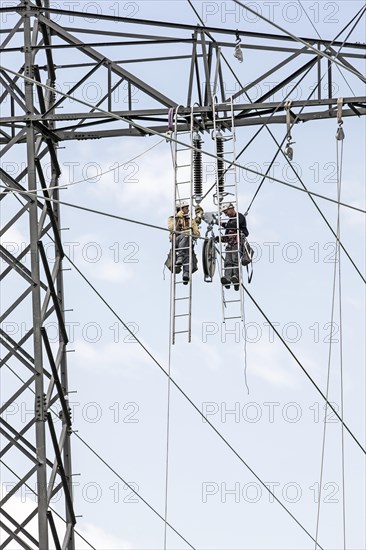 High-voltage service technicians installing a new high voltage power line