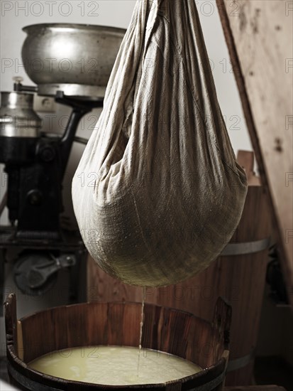 Lifting and pressing curd with a cheese cloth