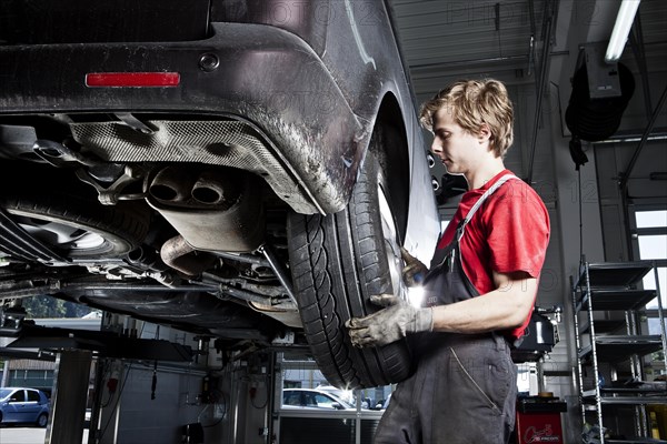 Car mechanic changing tyres in a car repair shop