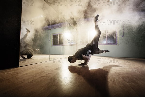 Breakdancer dancing in front of a mirror wall