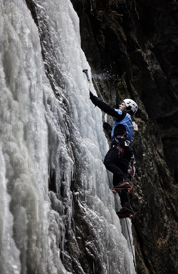 Ice climber climbing a frozen waterfall