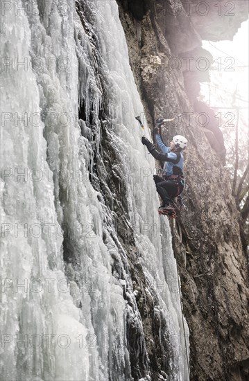 Ice climber climbing a frozen waterfall