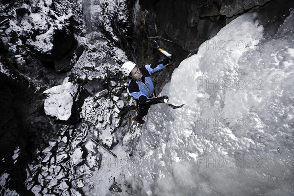 Ice climber climbing a frozen waterfall