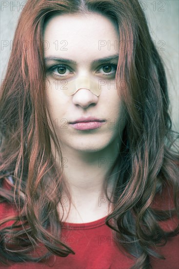 Portrait of a young woman with a band-aid on her nose