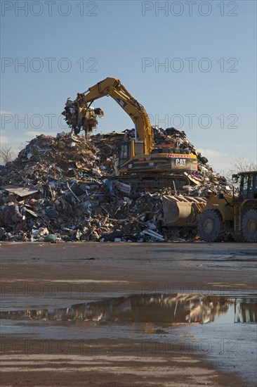 Workers pile debris from Hurricane Sandy in a parking lot next to the beach on Staten Island