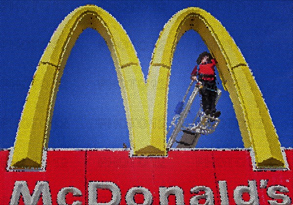 Worker repairing a Golden Arches sign