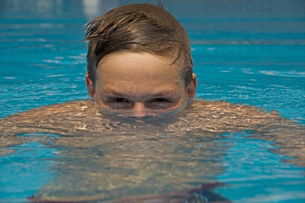 Young emerges from the water in a swimming pool