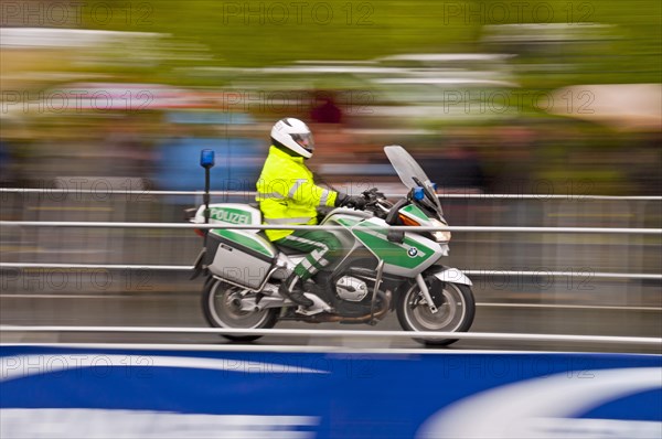 Accompanying motorcycle of the Rund um Koeln cycling race during rainy weather