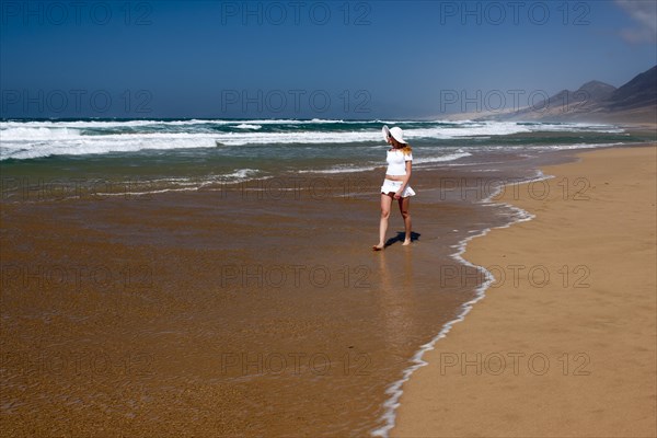 Woman walking along a sandy beach