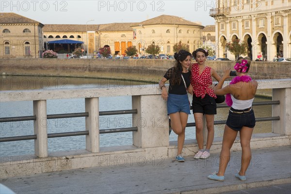 Women posing on the bridge crossing the Nevole River during the Summer Jamboree Rock'n'Roll Festival