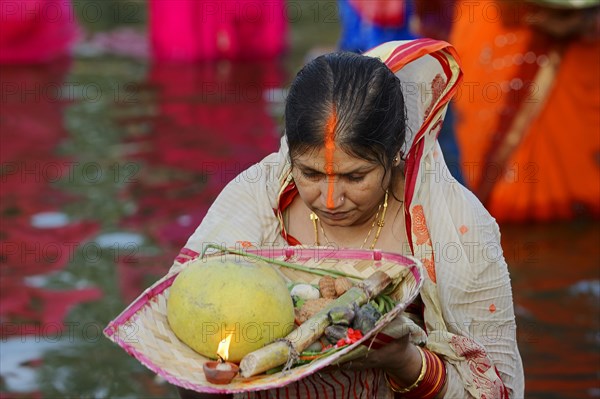 Woman wearing a sari with offerings during the Hindu Chhath Festival