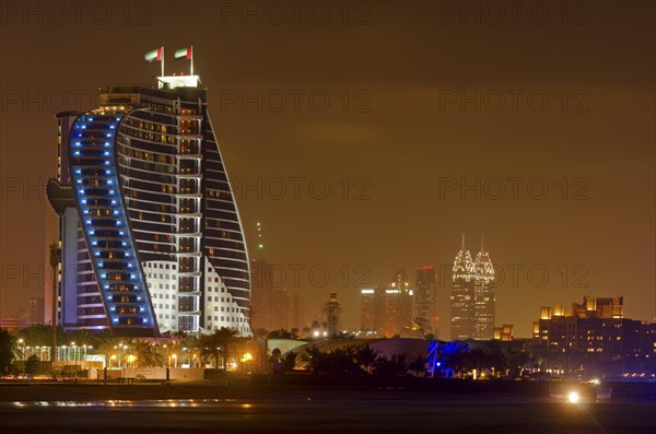 The illuminated Jumeirah Beach Hotel on Jumeirah beach at dusk