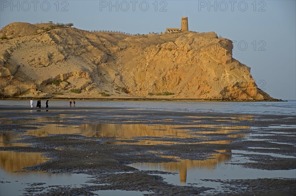 The rocky coast in Al Sawadi at the Gulf of Oman with a tower