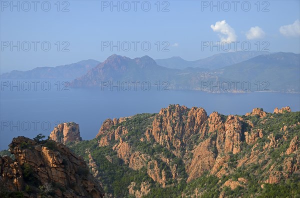 The typical bizarre red rocks of the Calanche of Piana and the mediterranean sea at the Gulf of Porto in the background. The Calanche of Piana is in the western part of the island Corsica