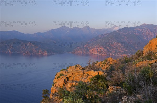 The typical bizarre red rocks of the Calanche of Piana and the mediterranean sea at the Gulf of Porto in the background. The Calanche of Piana is in the western part of the island Corsica