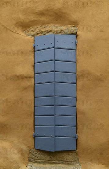 Yellow house wall and a closed blue door