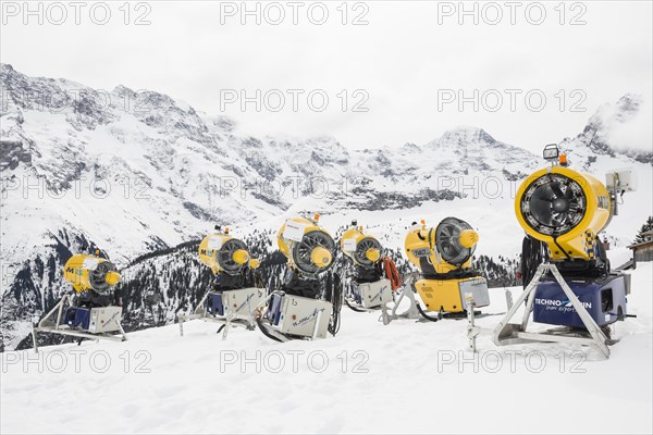 Snow cannon and snow-covered mountains