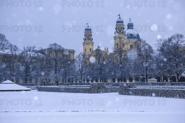 Hofgarten garden with Theatinerkirche St. Cajetan church in driving snow