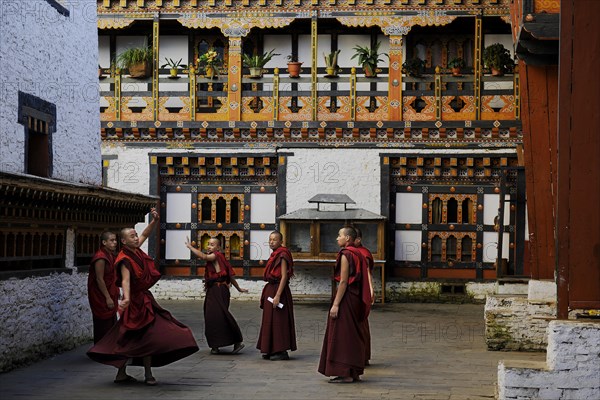 Group of young monks practicing a religious dance in the courtyard of Mongar Dzong fortress