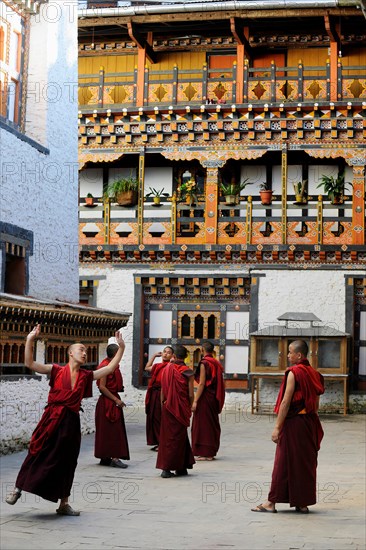 Group of young monks practicing a religious dance in the courtyard of Mongar Dzong fortress