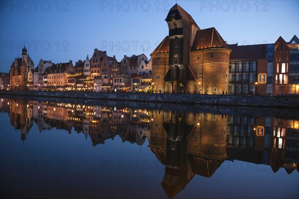 Crane Gate or Brama Zuraw in the historic row of houses at dusk