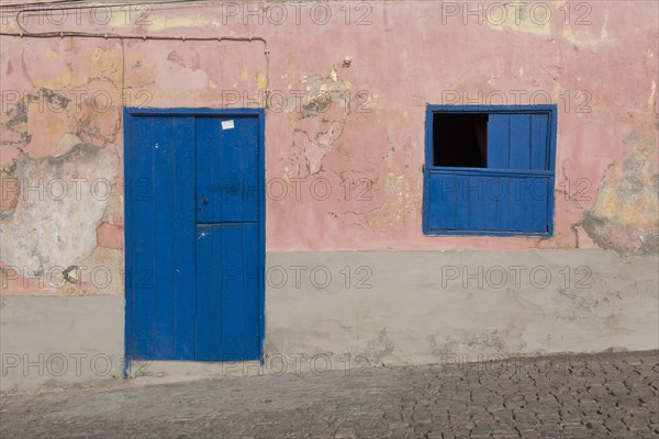 House facade with a blue door and a blue window