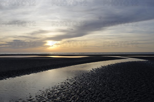 Sunset over a beach at low tide