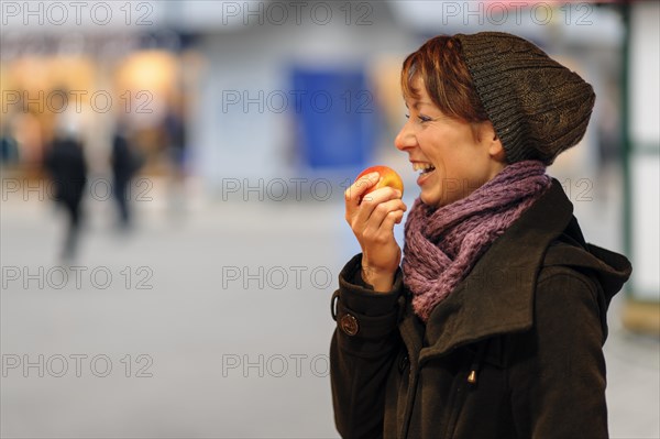 Smiling young woman eating an apple