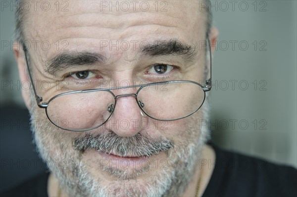 Smiling elderly man looking over his glasses