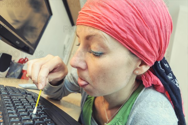 Cleaning lady cleaning a computer keyboard with a cotton swab