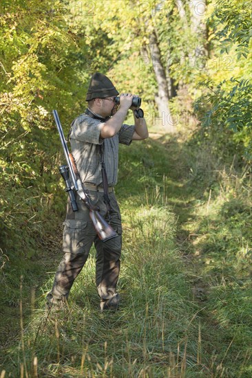 Hunter observing game with binoculars