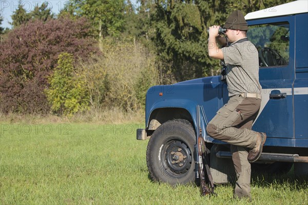 Hunter watching the area with binoculars