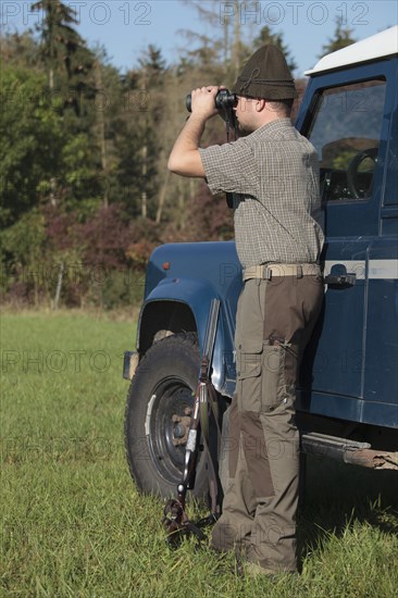 Hunter watching game with binoculars