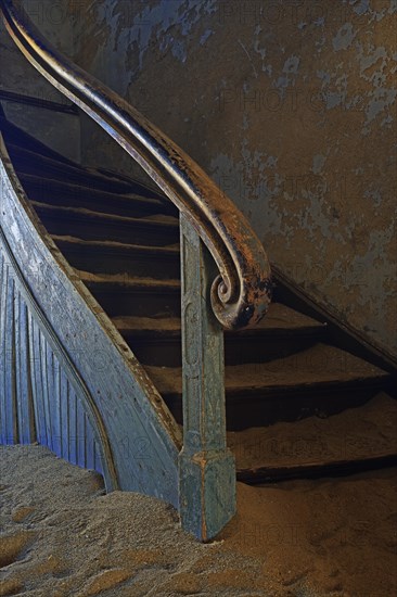 Staircase in a house that has been filled by desert sand