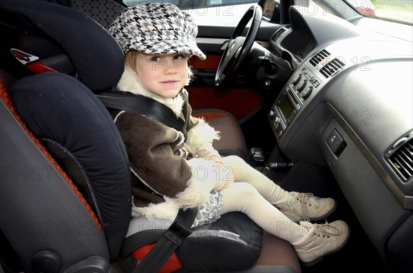 Girl in a car safety seat in a car