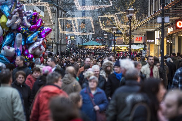Crowds thronging between stores and Christmas market stalls