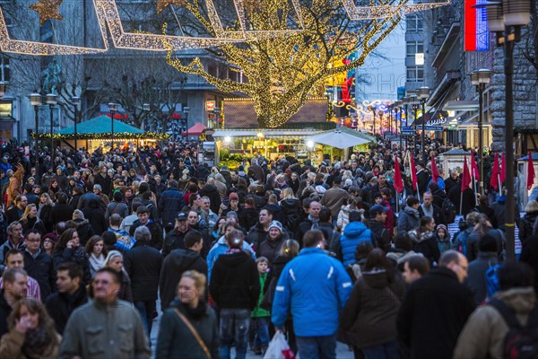 Crowds thronging between stores and Christmas market stalls