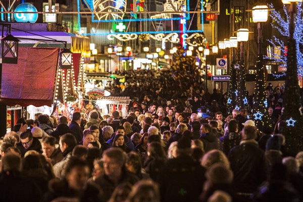 Crowds of people shoving through shops and Christmas market stalls