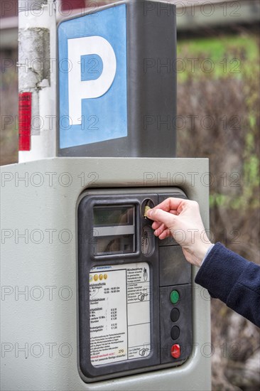 Woman purchasing a parking ticket from a parking ticket vending machine